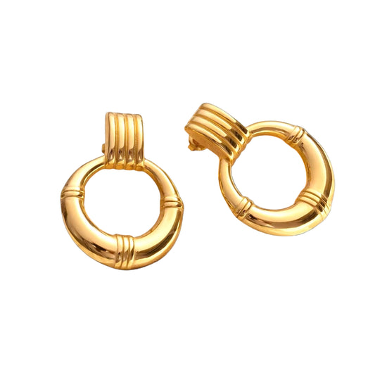 Pair of gold hoop earrings on a black background